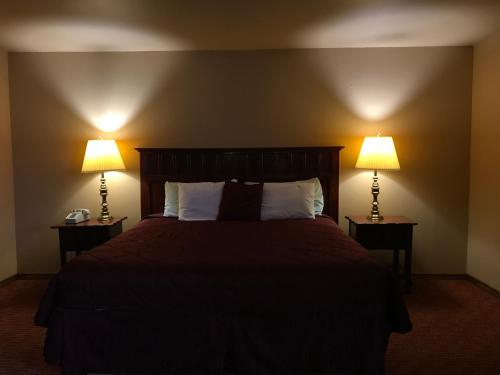 1 dormitorio con 1 cama con 2 lámparas en ambos lados en Camino Real Hotel, en Eagle Pass