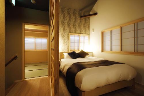 a bedroom with a bed and a door leading into a room at No.10 Kyoto House in Kyoto