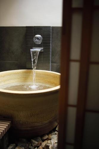 a bathroom with a tub with a water fountain at No.10 Kyoto House in Kyoto