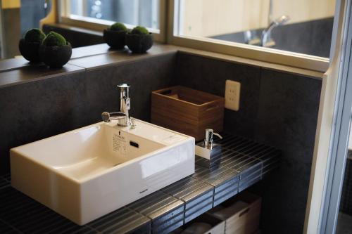 a bathroom with a white sink on a tiled counter at No.10 Kyoto House in Kyoto