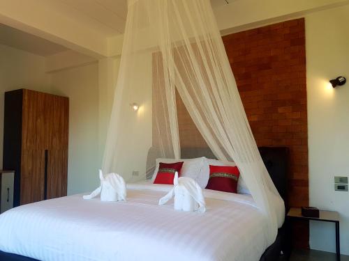 a bedroom with a large bed with white sheets and pillows at Chang Pai Hill in Pai