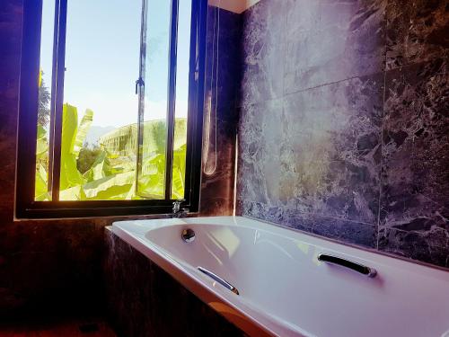 a white bath tub in a bathroom with a window at Chang Pai Hill in Pai