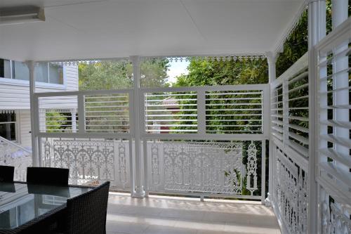 a screened in porch with a table and a window at North Ryde Guesthouse in Sydney