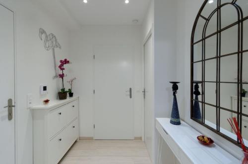 Cette chambre blanche dispose d'un miroir et d'une commode. dans l'établissement Red-line, à Serris