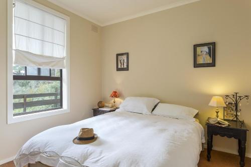 a bedroom with a bed with a hat on it at Salty Dog by the Sea - Pet Friendly in Rye
