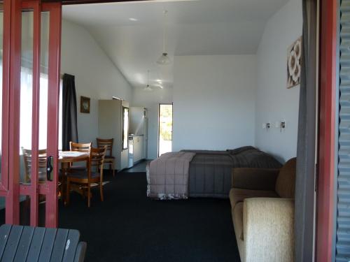 a bedroom with a bed and a table and a dining room at BeachView Motel in Greymouth