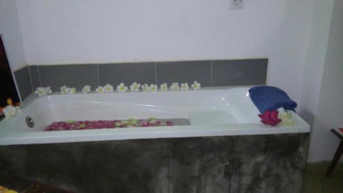 a bath tub with flowers and figurines in it at Suwa Arana Resort in Mirissa