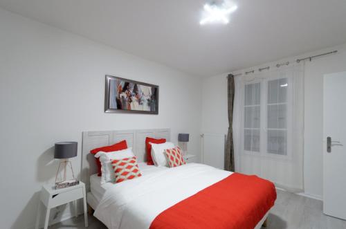 Schlafzimmer mit einem Bett mit roten und weißen Kissen in der Unterkunft Red-line in Serris