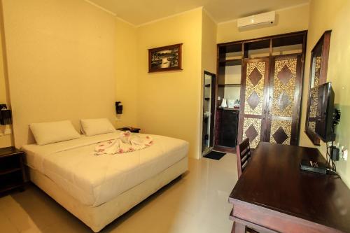 a bedroom with a bed and a table and a desk at Gili Buana Hostel & Backpackers Gili Air in Gili Air