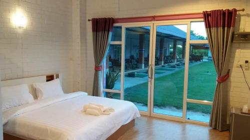 een slaapkamer met een bed en een groot raam bij Three Bays Resort in Prachuap Khiri Khan