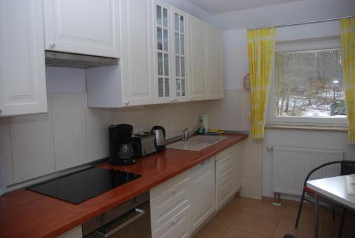 a kitchen with white cabinets and a sink and a window at Ferienwohnung Grünes Herz in Kiel