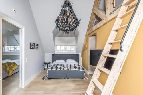 a bedroom with a bed and a staircase at De Herberg Appartementen in Renesse
