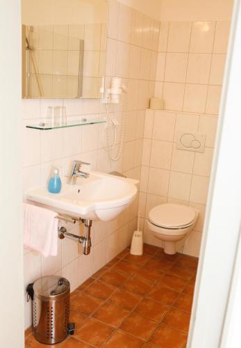 a bathroom with a sink and a toilet at Hotel Sonnenhof - bed & breakfast & appartements in Innsbruck