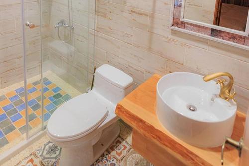 y baño con aseo blanco y lavamanos. en Nanchuang Wind Suzuki Coffee Houses, en Nanzhuang