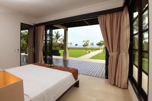 - une chambre avec un lit et une grande fenêtre dans l'établissement Villa Baruna, à Banjar