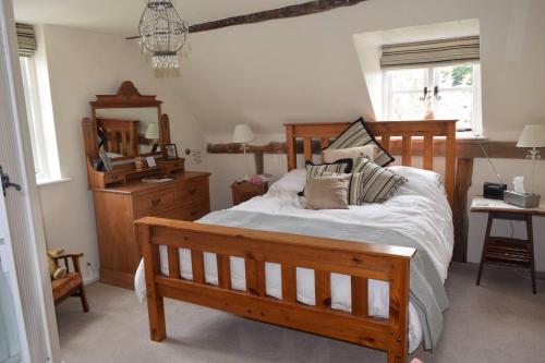 um quarto com uma cama de madeira com almofadas em The Rag House em Upton upon Severn