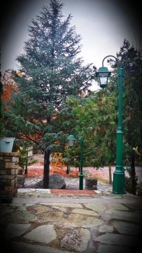 a park with two green light posts and a playground at River Side Rooms in Elassona