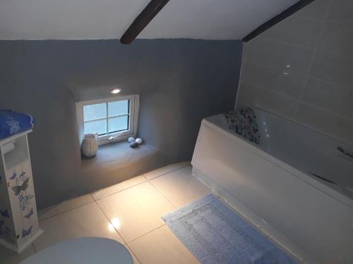 a bathroom with a white tub and a window at Sams cottage in Corderry