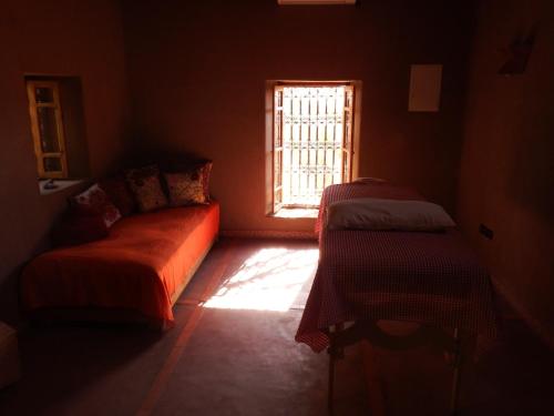 a dark room with a couch and a window at Dar Paru in Mhamid