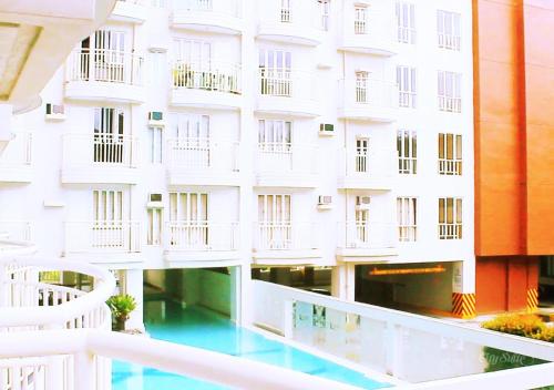 a white building with a swimming pool in front of it at Sky's at Prime Residences -Tagaytay in Tagaytay