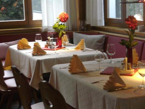 dos mesas en un restaurante con mantel blanco en Waldhotel Tropfsteinhöhle en Wiehl