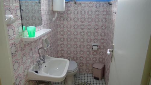 a small bathroom with a sink and a toilet at Poros House Hotel in Poros