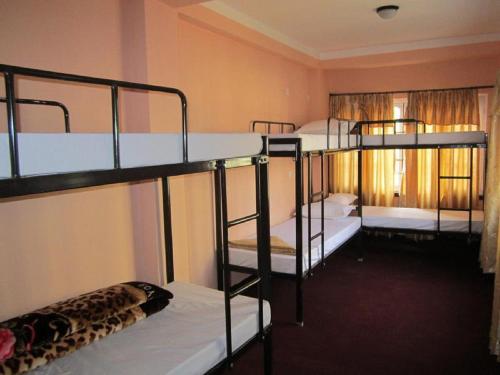 a room with three bunk beds in a hostel at Everest Home Stay Apartment in Pātan