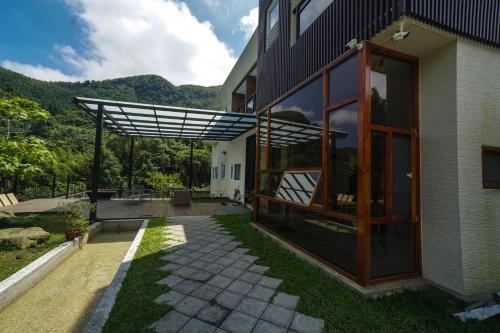 a house with a glass door and a patio at Xi Tou in Sunny Day Inn in Lugu Lake