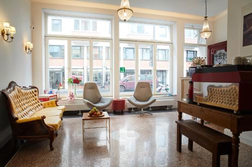 a living room with chairs and a piano at MAISON MARSIL - Boutique Hotel Köln in Cologne