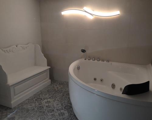 a white bathroom with a tub and a sink at Door Eight in Il-Furjana
