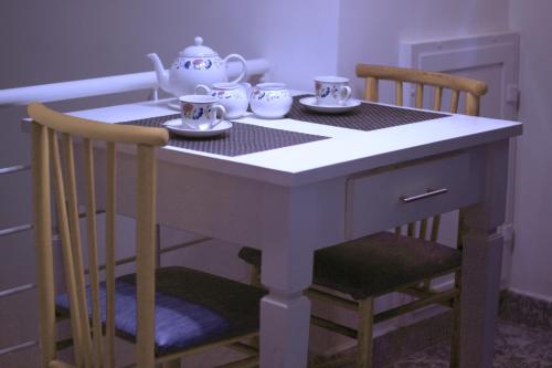 a table with two chairs and a tea set on it at Door Eight in Il-Furjana
