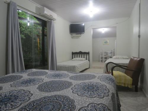 1 dormitorio con 2 camas, ventana y TV en Solar Vovó Emma House, en Penha