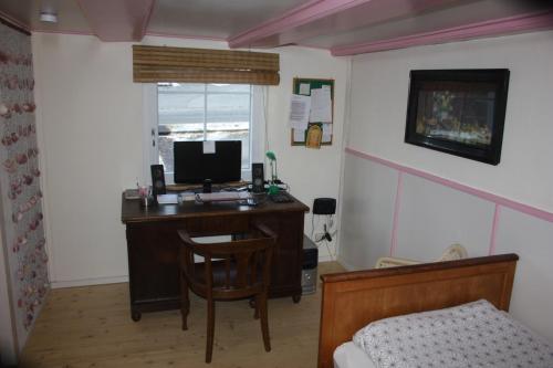 a bedroom with a desk with a computer and a bed at Ferienwohnung Fink in Tengen