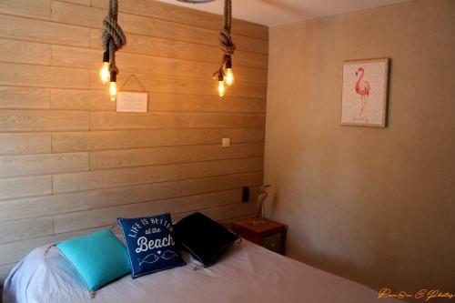 Schlafzimmer mit einem Bett mit blauen Kissen und Lampen in der Unterkunft Le flamant - Appartement P2 de 40m2 grande terrasse-parking-wifi in La Grande-Motte