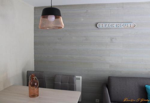 a dining room with a table and a light fixture at Le flamant - Appartement P2 de 40m2 grande terrasse-parking-wifi in La Grande-Motte