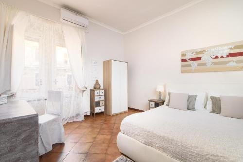 a white bedroom with a bed and a window at Finally Roma Apartment in Rome