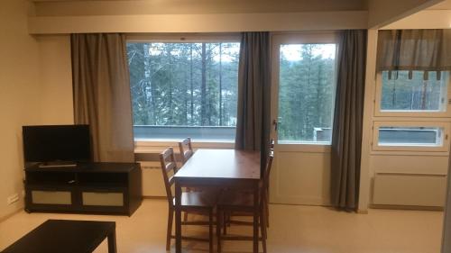a dining room with a table and chairs and a window at Kotipaljakka in Kotila