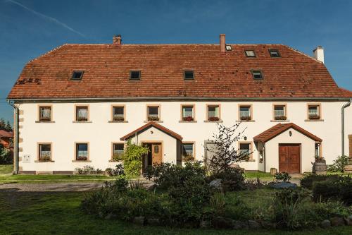 uma grande casa branca com um telhado vermelho em Winnica Agat em Świerzawa