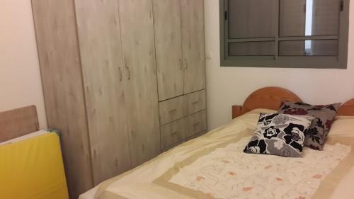 a bedroom with a bed and a wooden cabinet at Holiday home in Galilee in Sheʼar Yashuv