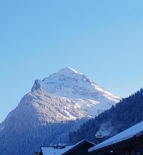 a snow covered mountain in the distance with a house at Le Marquis in Morzine