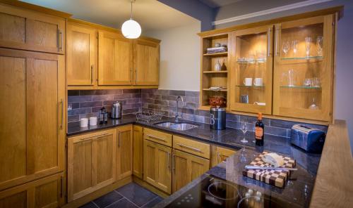a kitchen with wooden cabinets and a counter top at The Garden Apartment in Keswick