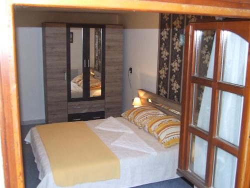 a bedroom with a bed and a mirror at Eszter Vendégház in Tiszafüred