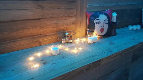 a bench with candles and a picture of a woman at Aqua Apartments Spa Housemuhlbach in Sappada