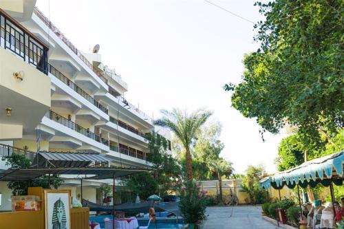 an apartment building with a patio and a restaurant at Rezeiky Hotel & Camp in Luxor