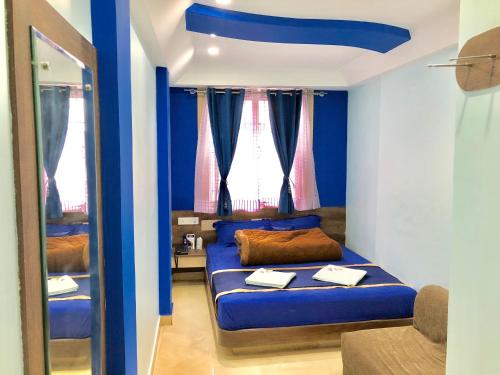 a blue room with a bed and a mirror at Hotel Landmark in Ooty