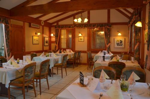Un comedor con mesas y sillas blancas. en Landhaus Schaaf, en Runkel