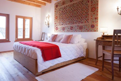 sypialnia z łóżkiem z czerwonym kocem w obiekcie COLVAGO COL DI LUNA – DOLOMITES NATIONAL PARK w mieście Santa Giustina