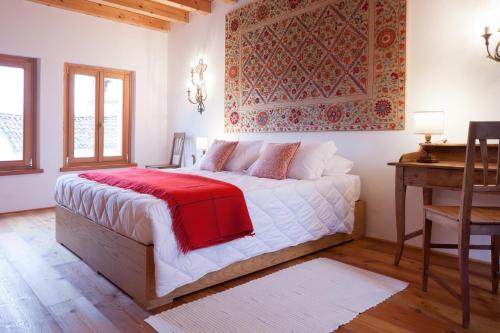 een slaapkamer met een bed met een rode deken erop bij COLVAGO COL DI LUNA – DOLOMITES NATIONAL PARK in Santa Giustina