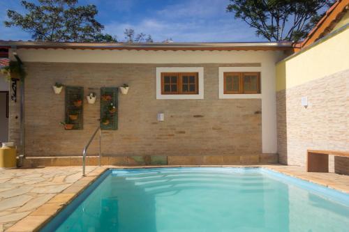 une piscine devant une maison dans l'établissement Villa Cottage Pousada, à Monte Alegre do Sul