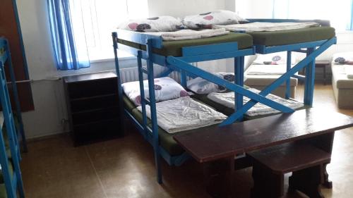 two bunk beds in a room with a table at Turistická ubytovna Zámeček in Hojsova Stráž